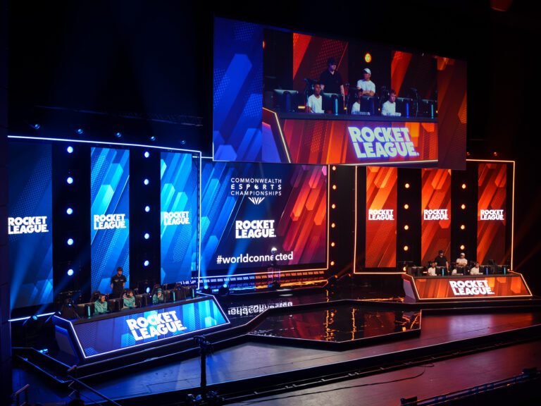 Image of staging made up of 3 panels of LED wall on each side, one half has red colours, one half has blue colours