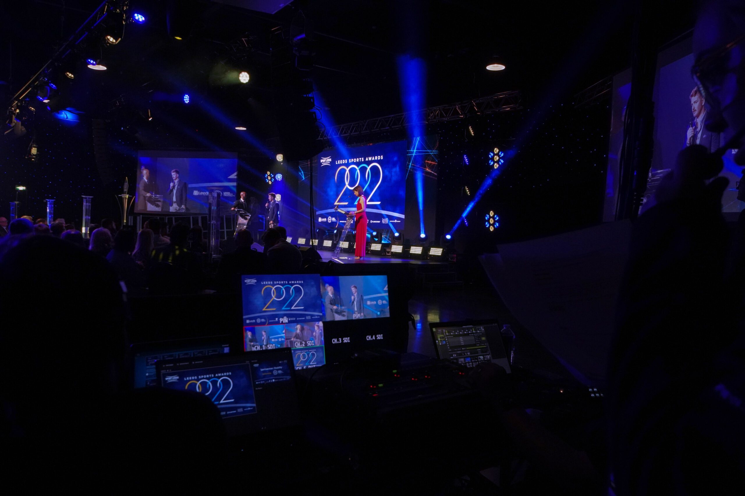 stage with presenter and blue lights at the leeds sports awards 2022
