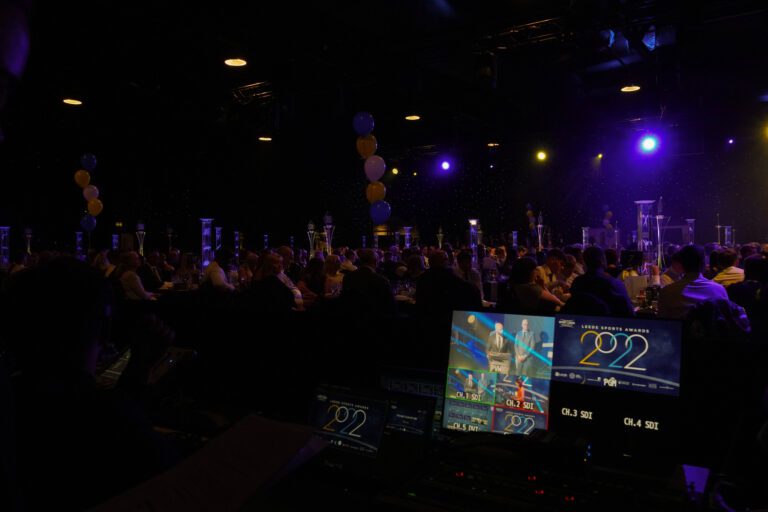 image of vision mixer display with audience in the background
