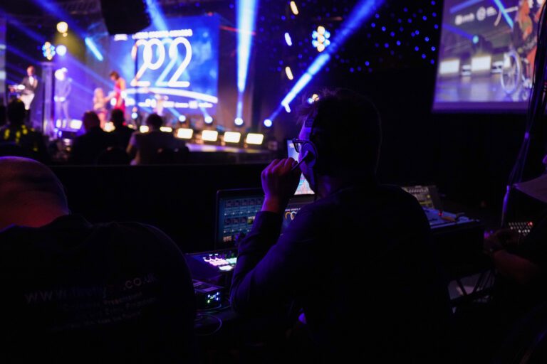 tech in the foreground with full lighting display in the background. Screen that says Leeds Sports Awards 2022