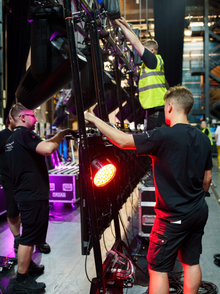 Image of firefly employees working back stage with equipment