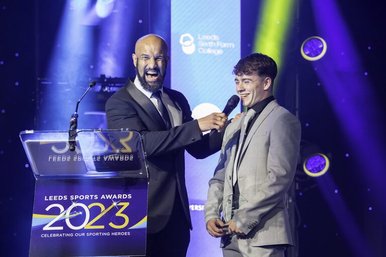 Leeds sports event with a man handing an award to another man